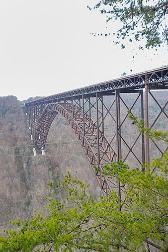 View of a steel bridge that spans a deep ravine between mountains. 